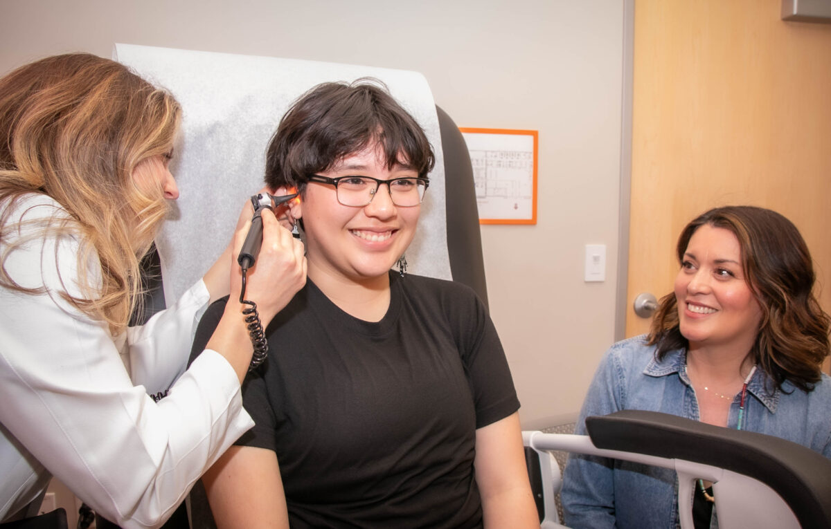 A person having their ears checked by a doctor