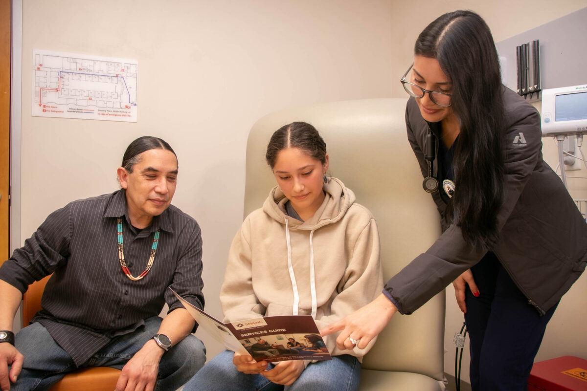 A doctor pointing at a brochure that a patient is reading